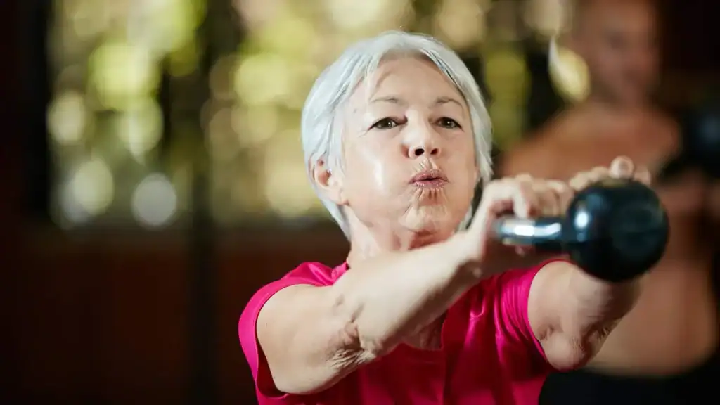 Toning Arms After 60: Empowering Womens Fitness Through Effective Weight Training 1 Older woman doing weight training Rushden to help her strength and longevity