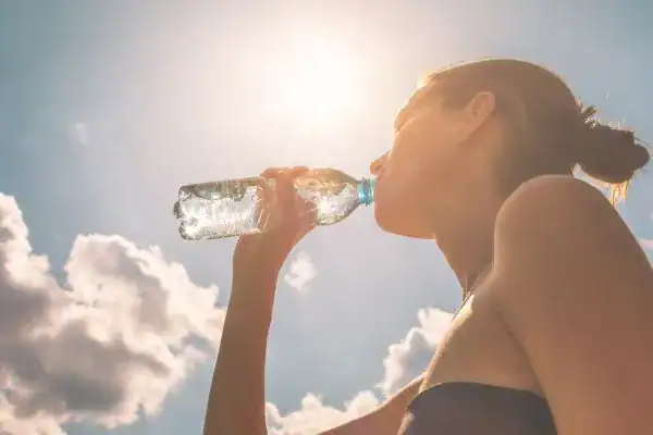 Hydration: The Secret Ingredient for a Toned Stomach and Enhanced Fitness 3 Image of woman drinking water to hydrate Rushden after run.