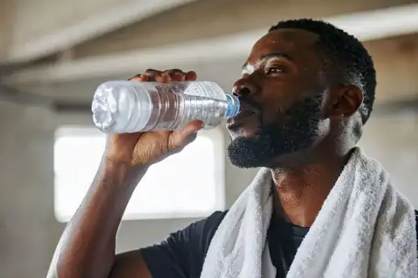 Hydration: The Secret Ingredient for a Toned Stomach and Enhanced Fitness 1 Image of man drinking water to improve hydration Rushden after work out.